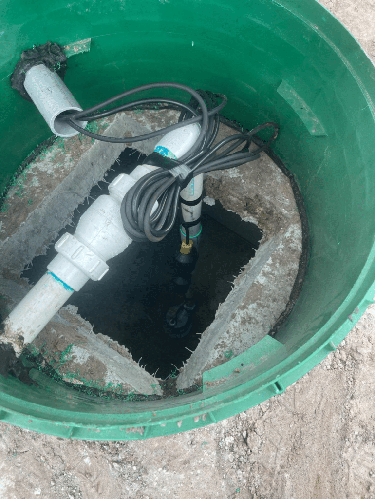 An open green riser reveals the internal pump system and PVC piping during a septic tank pumping spring hill fl service.